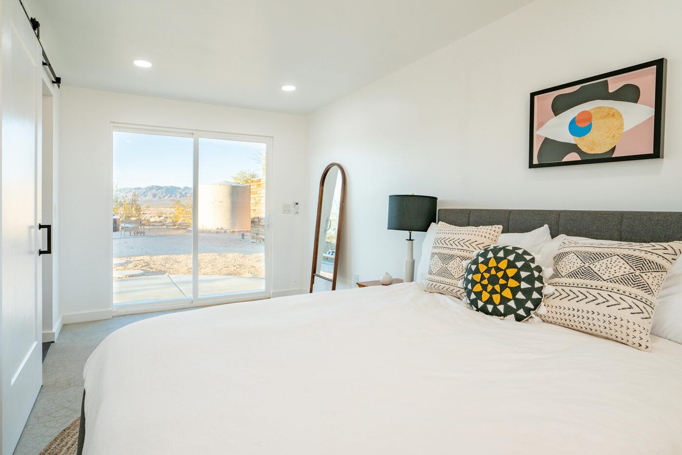 An ADU bedroom on polished concrete, opening to the patio