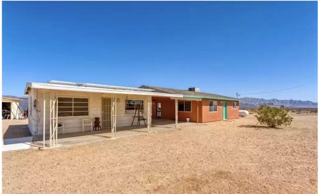 Before — the garage building, now the ADU with a concrete patio off the sliders